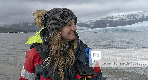 Close-up view of a woman with blond hair  wearing a woolen hat  enjoying a boat tour on Fjallsárlón Glacier Lagoon; South Iceland  Iceland