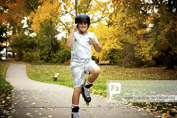 Teenage boy inline skating in a city park during a warm fall day; St. Albert  Alberta  Canada