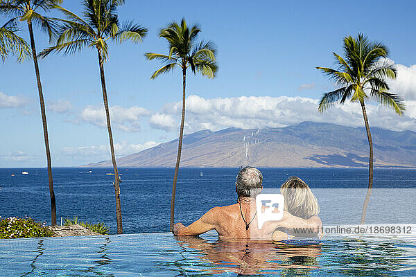 View taken from behind of a couple enjoying the ocean view from the infinity pool at The Four Seasons Resort; Wailea  Maui  Hawaii  United States of America