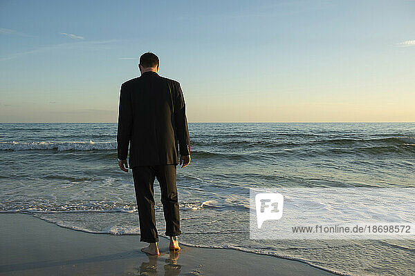 Man in a suit walks into the ocean; Panama City Beach  Florida  United States of America