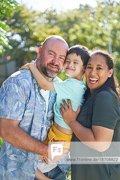 Portrait happy parents holding son with Down Syndrome