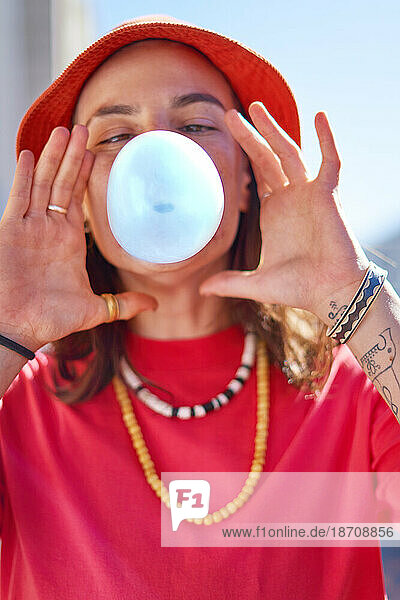 Close up portrait young woman blowing bubble with bubble gum