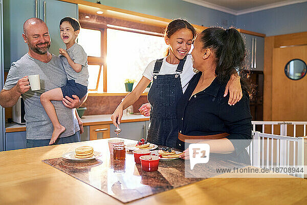Happy family eating pancakes in morning kitchen