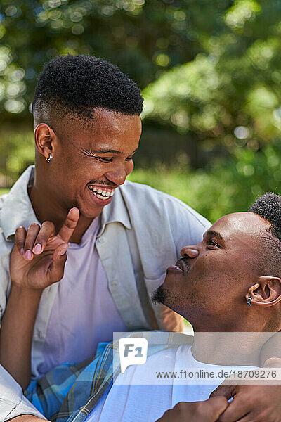 Happy  affectionate young gay male couple laughing and hugging