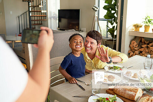 Happy mother and son posing for photo at dinner table