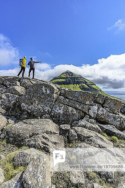 Tourists looking at the fjord during a hike to Skaelingsfjall mountain in summer  Streymoy Island  Faroe Islands  Denmark  Europe
