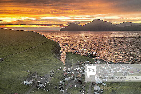 Fiery sky at dawn over Kalsoy island and the village of Gjogv  overhead view  Eysturoy Island  Faroe Islands  Denmark  Europe