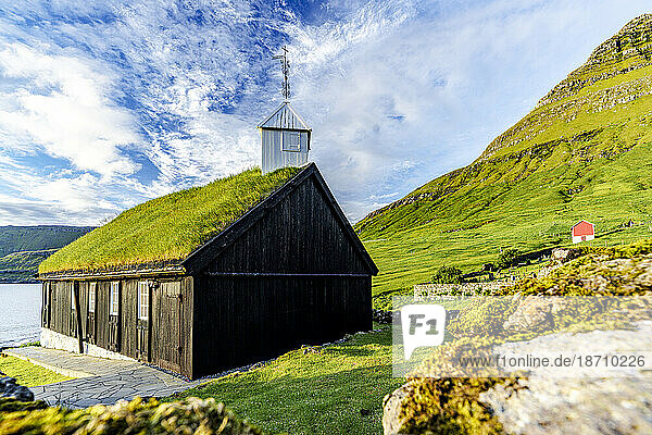 Traditional church with grass roof overlooking the fjord  Funningur  Eysturoy Island  Faroe Islands  Denmark  Europe