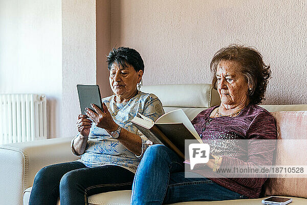 two old women reading with electronic book and paper book