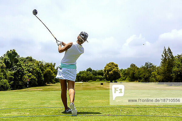 Rear view of young woman playing golf