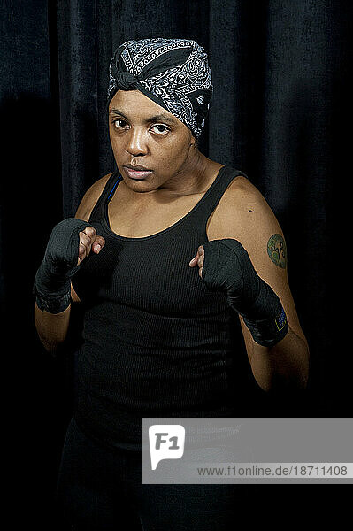 A female boxer wearing a headband holds her hands up in a defensive posture in a portrait at the Canadian Amateur Boxing Championships in Saint-Hyacinthe  Quebec.