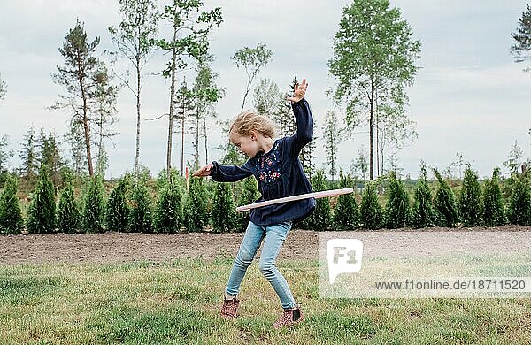 young girl in her garden playing with a hula hoop
