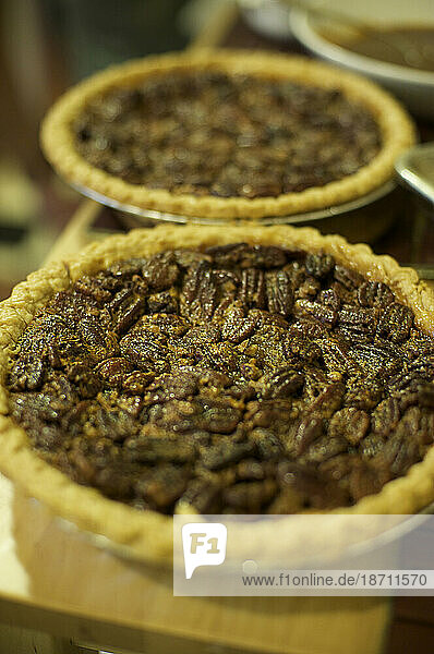 Two pecan pies sit on a countertop.