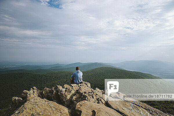 A young adult overlooks a wide mountain range in Virginia.
