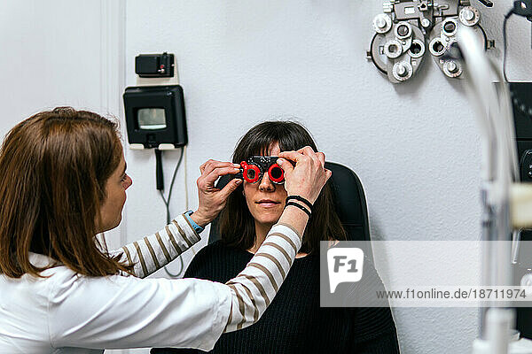 oculist measuring diotrics to a patient in an optician