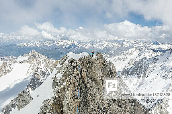 Alpinist poses high up on the famous Forbes Arete in the French Alps