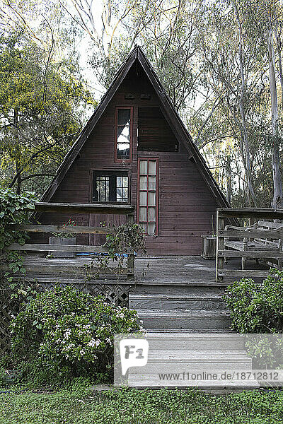 An old  decrepit  wooden  triangular shaped guest house sits in lush green foliage in Del Mar  California.