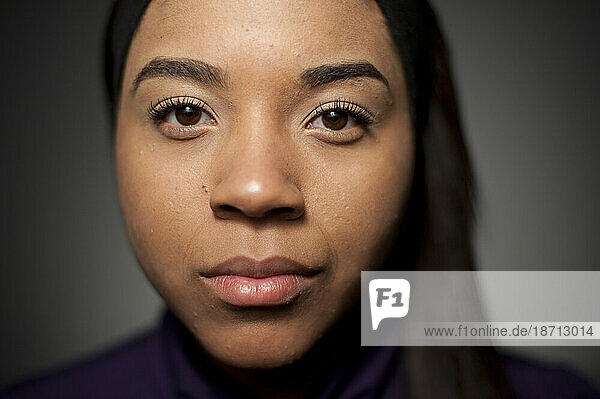 Studio closeup portrait of 21 year old African American woman.