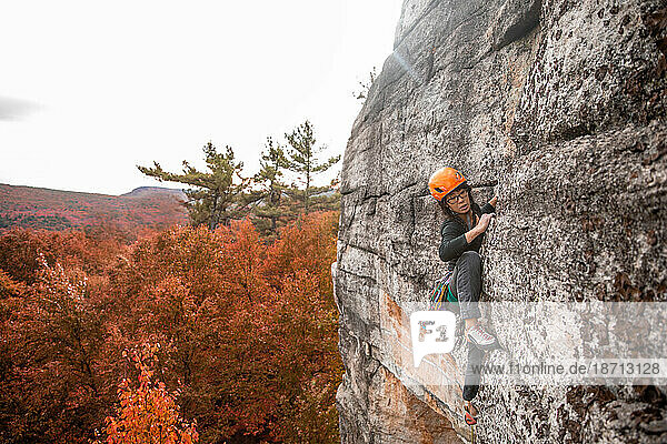 Woman climbing in the fall in the Gunks