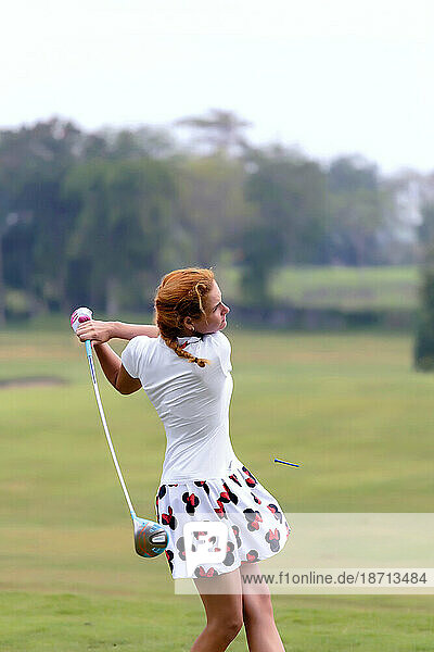 Woman in skirt playing golf