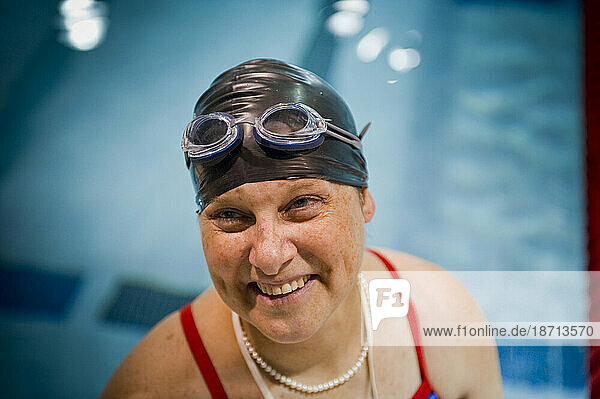 A female paraplegic athlete smiles before starting her swim practice.
