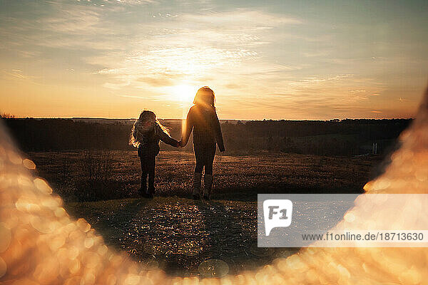 Two young girls looking into sunset