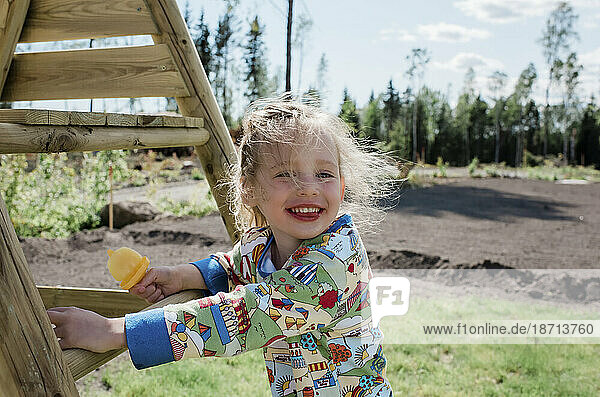 happy young girl eating an ice lolly at home in the garden