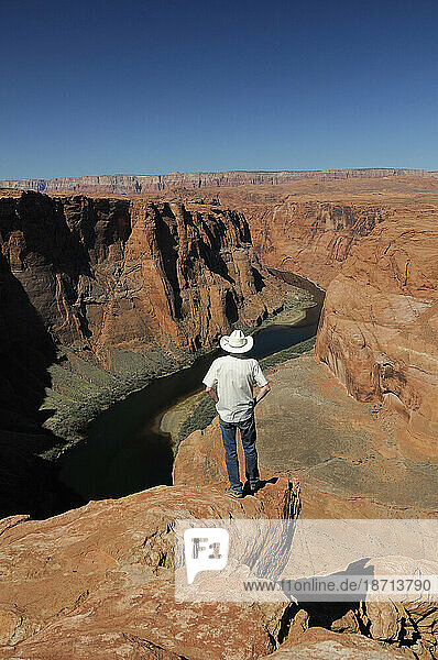 A man at Horseshoe Bend  overlooking the Colorado River near Page  Arizona  USA