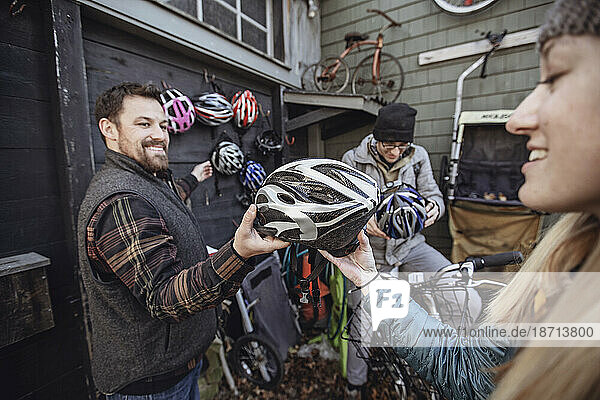 A young man passes out bike helmets at a bike rental shop