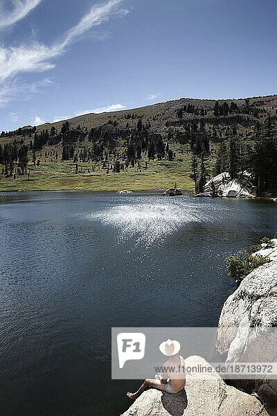 A hiker catches some sun at Showers Lake along the Tahoe Rim Trail.