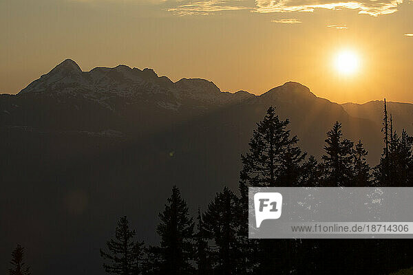 Scenic of sun setting over the mountain tops on a spring day.
