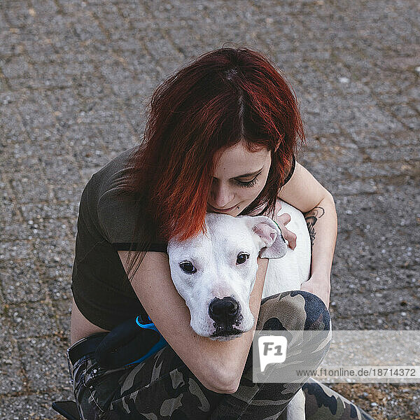 The woman is hugging her dog - dogo argentino