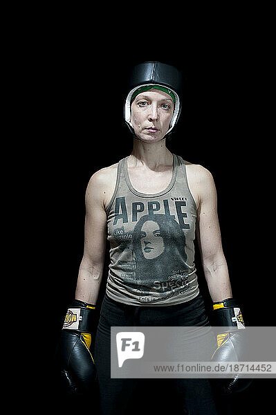 Three quarter portrait of female boxer wearing headgear and boxing gloves  Toronto  Ontario