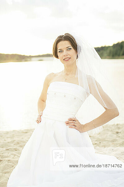 Portrait of bride standing on the beach in summer