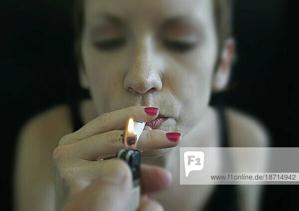 A woman lights up a cigarette  Nashville  Tennessee.