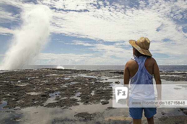 Man wearing straw hat and beach cloths  staring at waves  Samoa