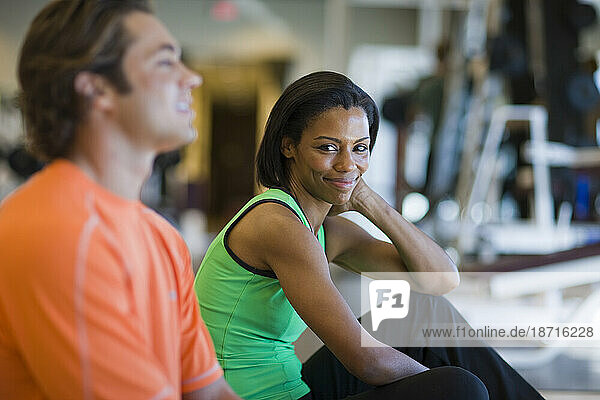A woman and a man take a break from working out.