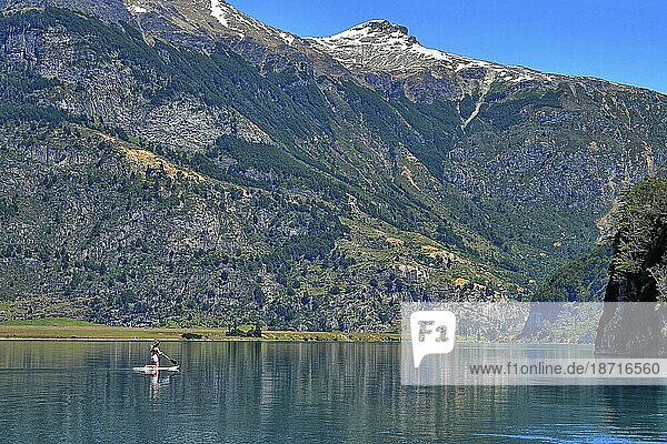 A lady paddle boards on a lake in Chile