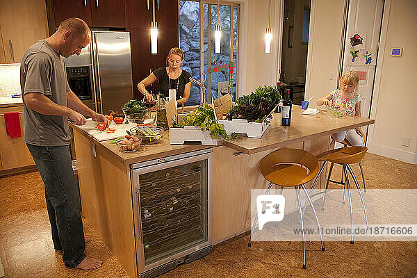 A family prepares dinner in their home with organic produce.