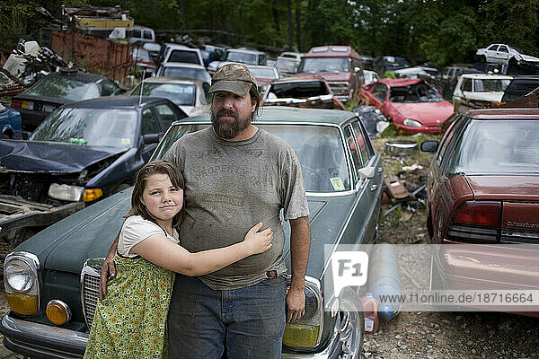 a man hugs his daughter in junkyard in NC.