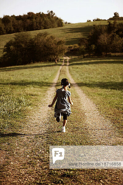 A young girl running down a country road in Frankenstein  Missouri.