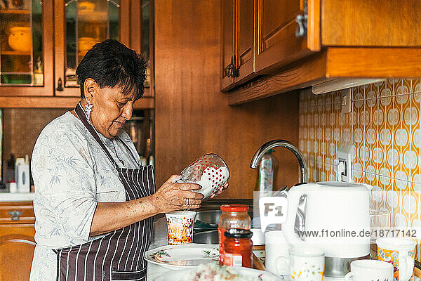 older latin American woman cooking at home