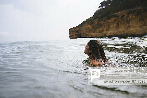 Woman swiming in wild beach in Tarragona  Spain.