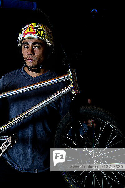 Portrait of a young latin boy sitting with his BMX bike.
