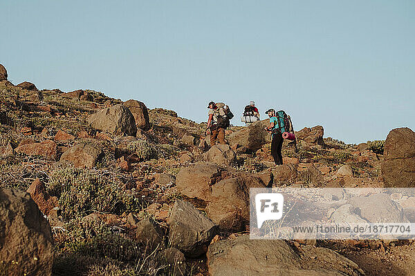 Hikers walking trough the rocks in a volcanic landscape