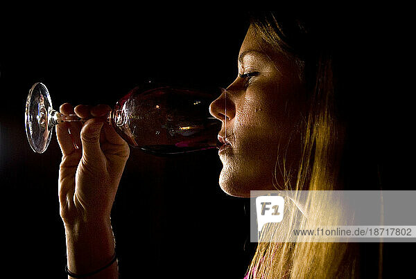A woman sips a glass of wine while wine tasting at a vineyard in Sonoma  California.
