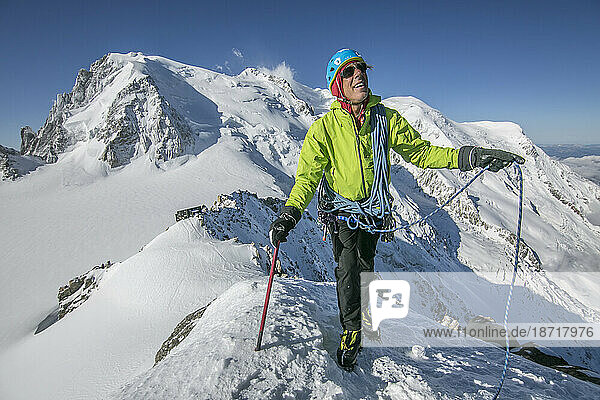 Smiling alpinist in his fifties takes in the scenery near Mt Blanc