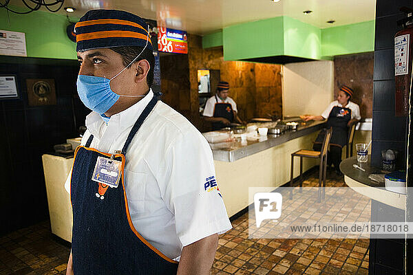 A chef in a taco restaurant wearing a mask in Mexico City  DF  Mexico.