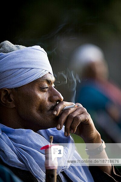 Portrait of an Egyptian man smoking a cigarette on the banks of the Nile river near Luxor  Egypt.