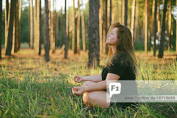 Young woman practicing yoga at sunrise